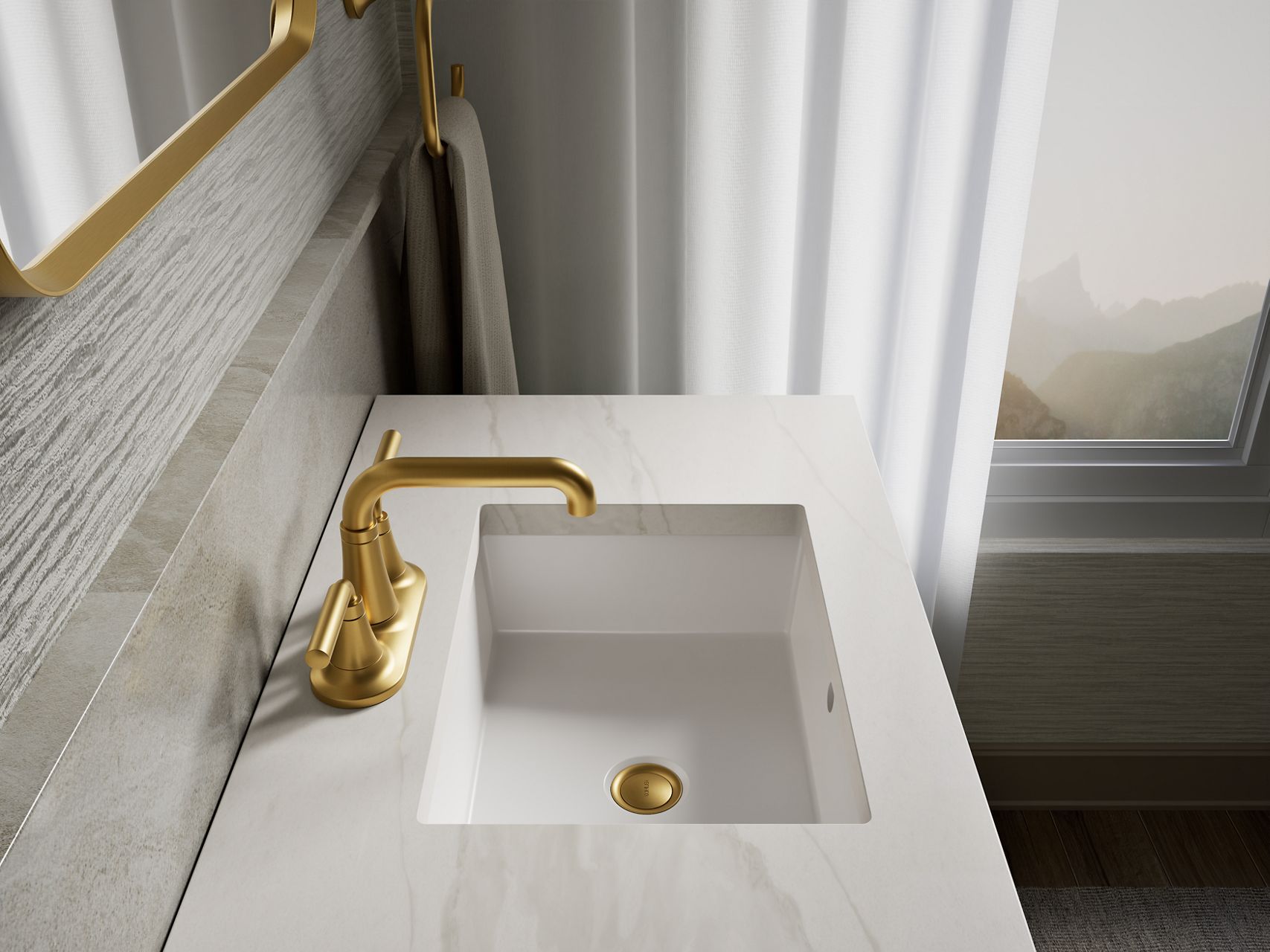 Rectangular undermount bathroom sink with a Vibrant Brushed Moderne Brass faucet and matching drain on a white marble countertop.