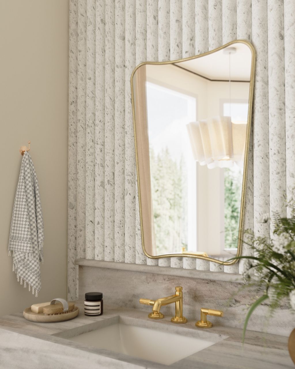 Brushed gold widespread bathroom faucet paired with a rectangular undermount sink, decorative mirror, and marble countertop in a light-filled bathroom.