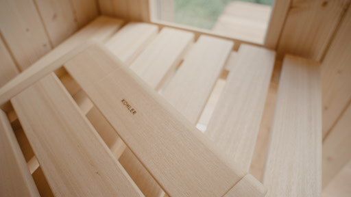 Close-up of handcrafted wooden benches inside a sauna cabin.