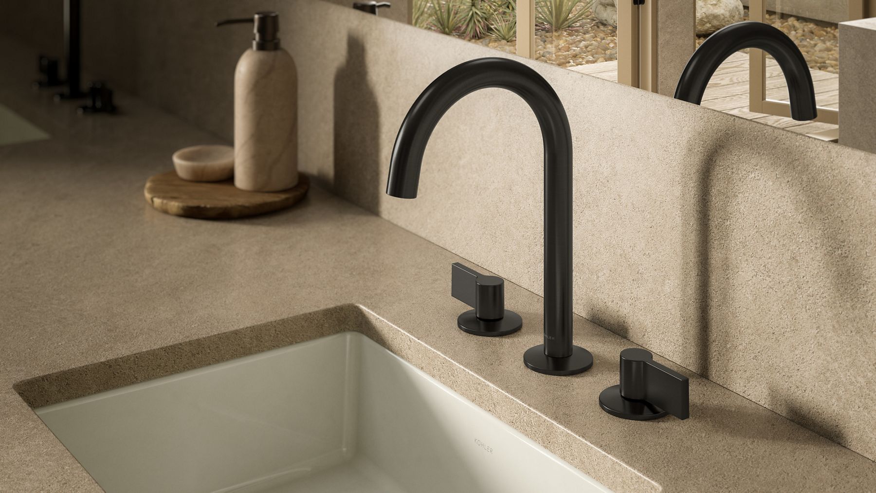 Matte black widespread bathroom faucet with coordinating handles installed on a textured stone countertop beside an undermount sink.