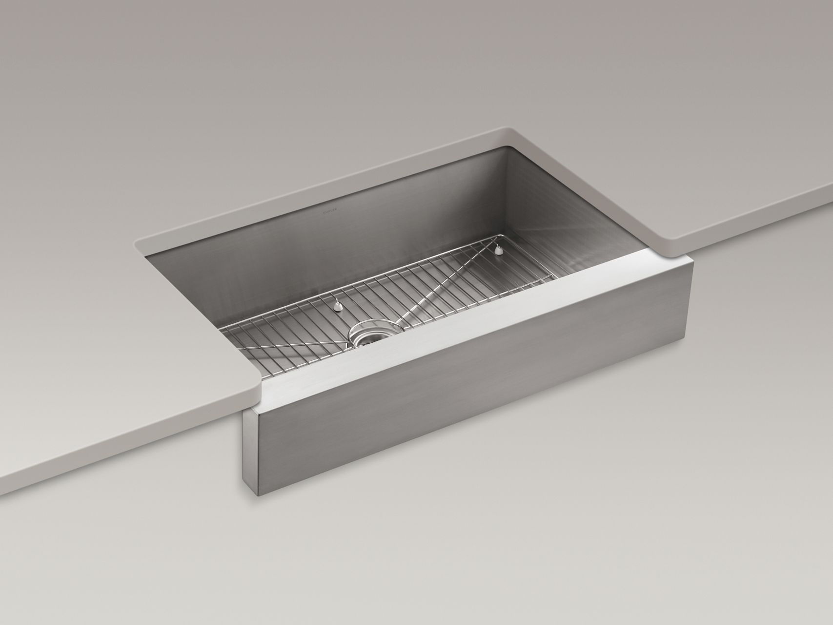 A close-up of a stainless steel sink with a sink rack at the bottom of the sink.