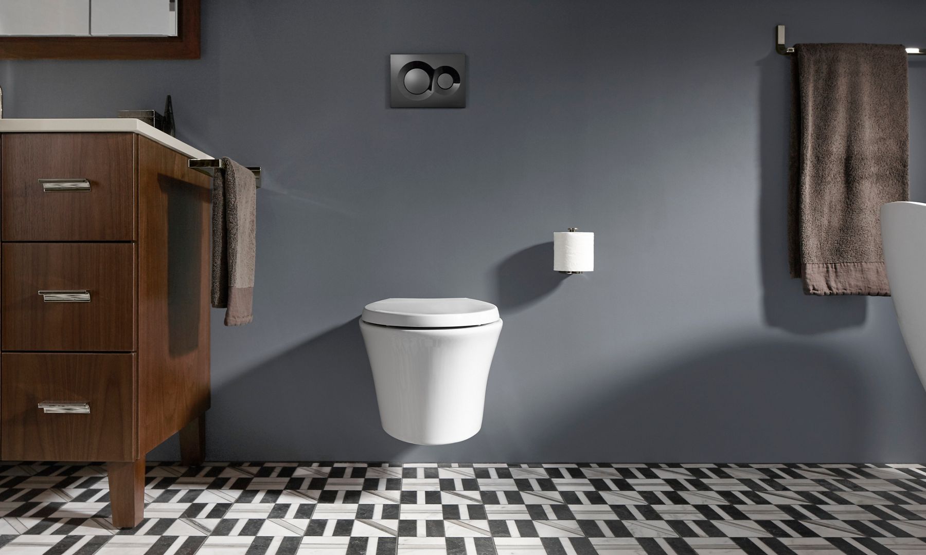 A white wall-mount toilet against a dark gray wall with a two-function flush panel above it.