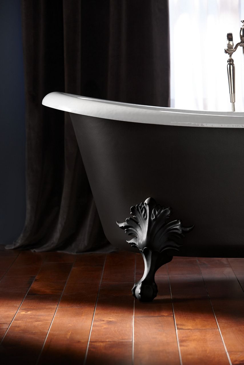 A KOHLER Artifacts Freestanding bath with Iron Black painted exterior and claw feet is the focal point in a dark, dramatic bathroom.