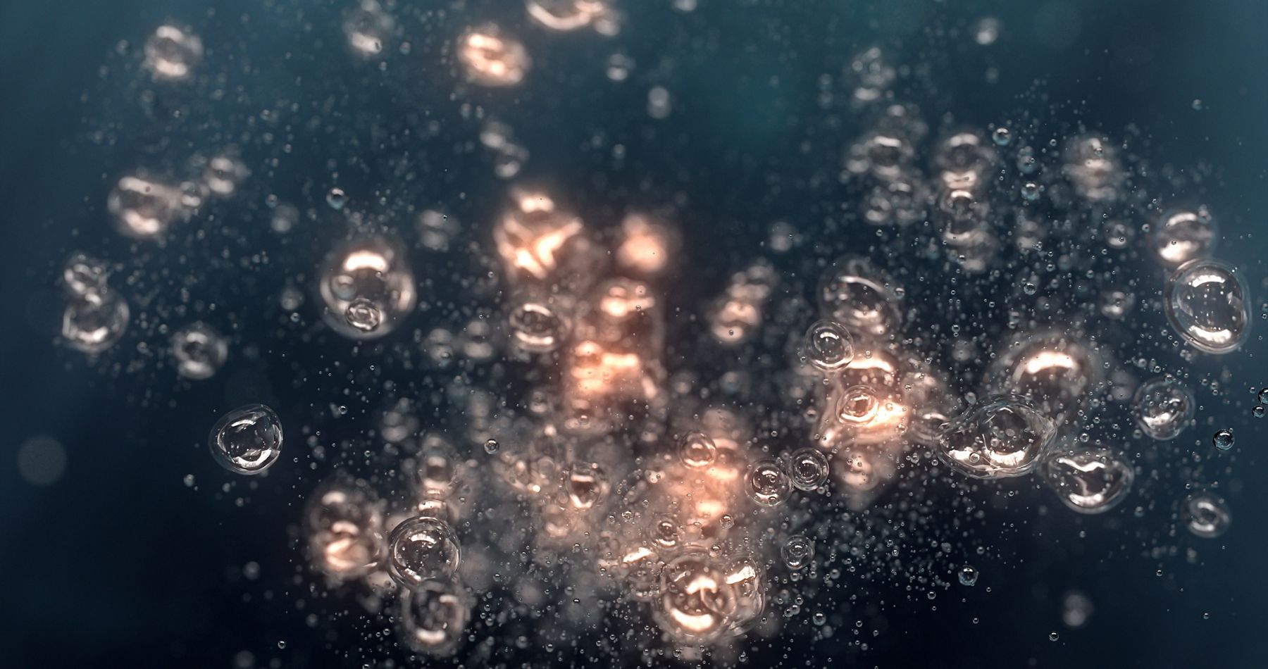 Large light-filled bubbles shown from under the surface of the water.