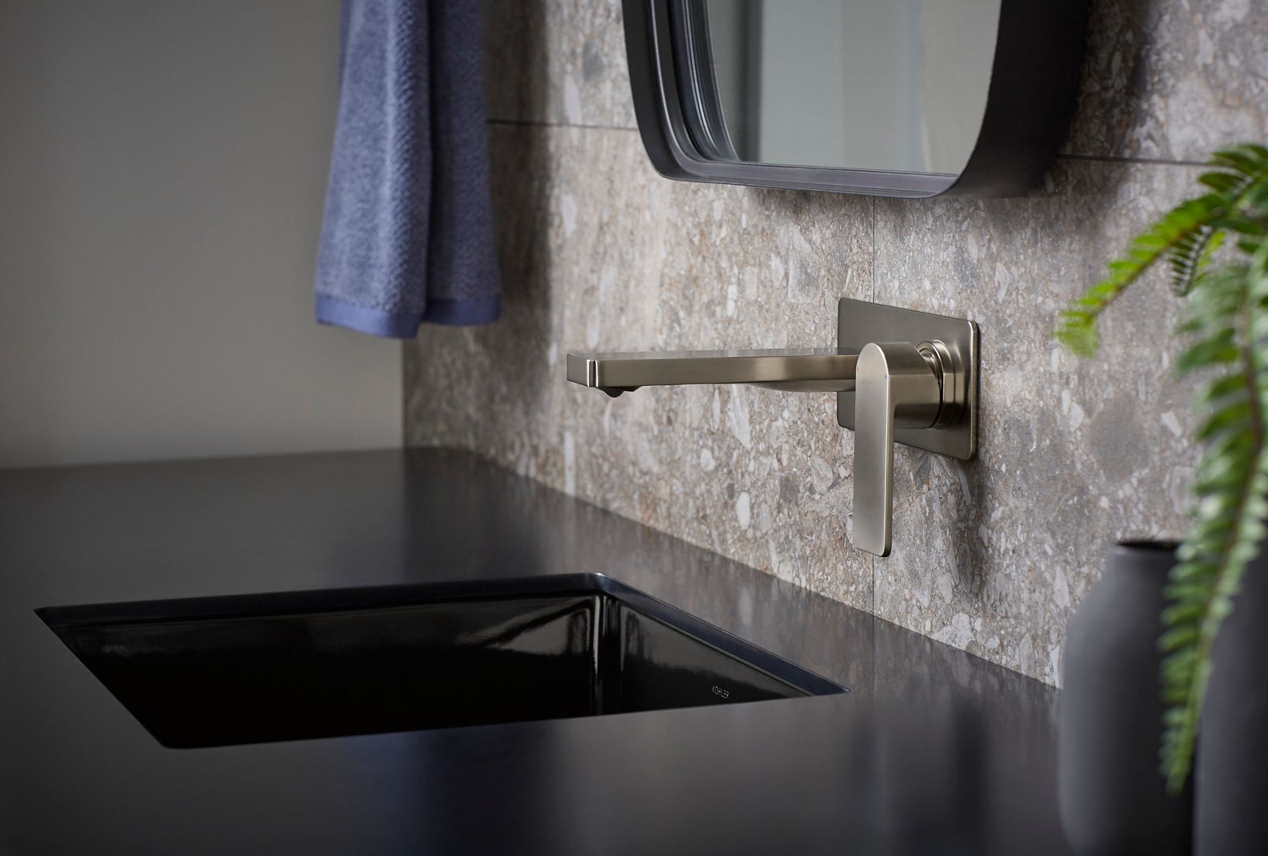 A wall-mount faucet in brushed nickel with rectangular details.