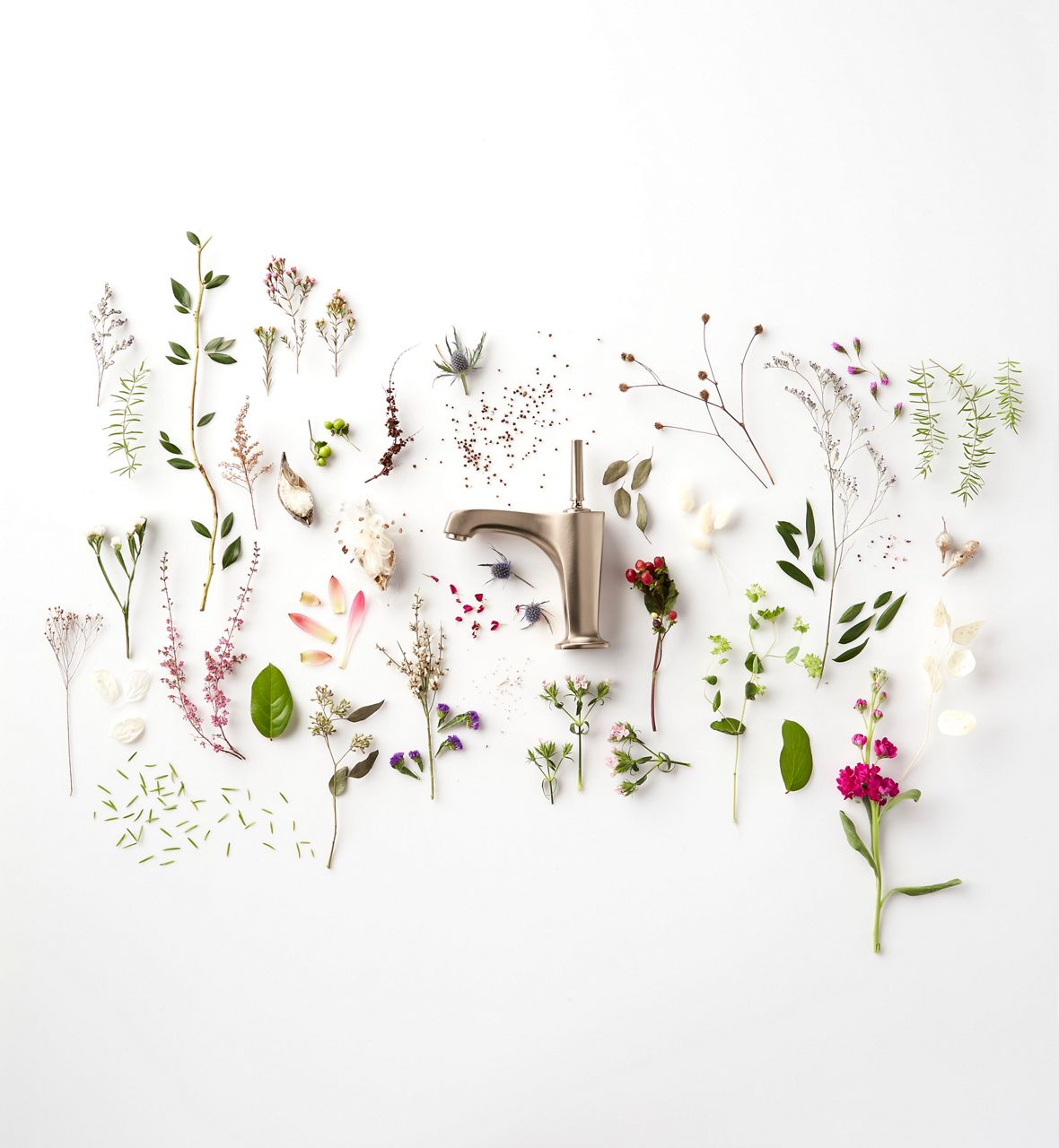 Un robinet de baignoire Kohler vu de côté, entouré de fleurs printanières et de verdure.