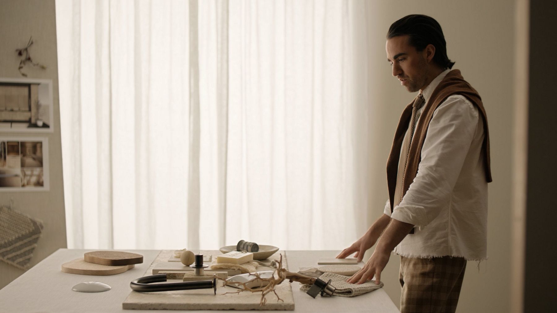 Jake Arnold wearing a long sleeve shirt looking at a table filled with materials on it.