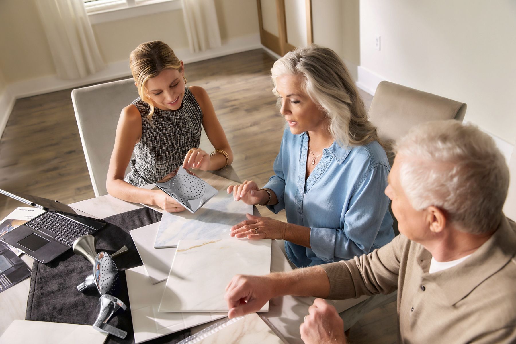 Three people reviewing paperwork at a desk discussing VA coverage for walk-in tubs