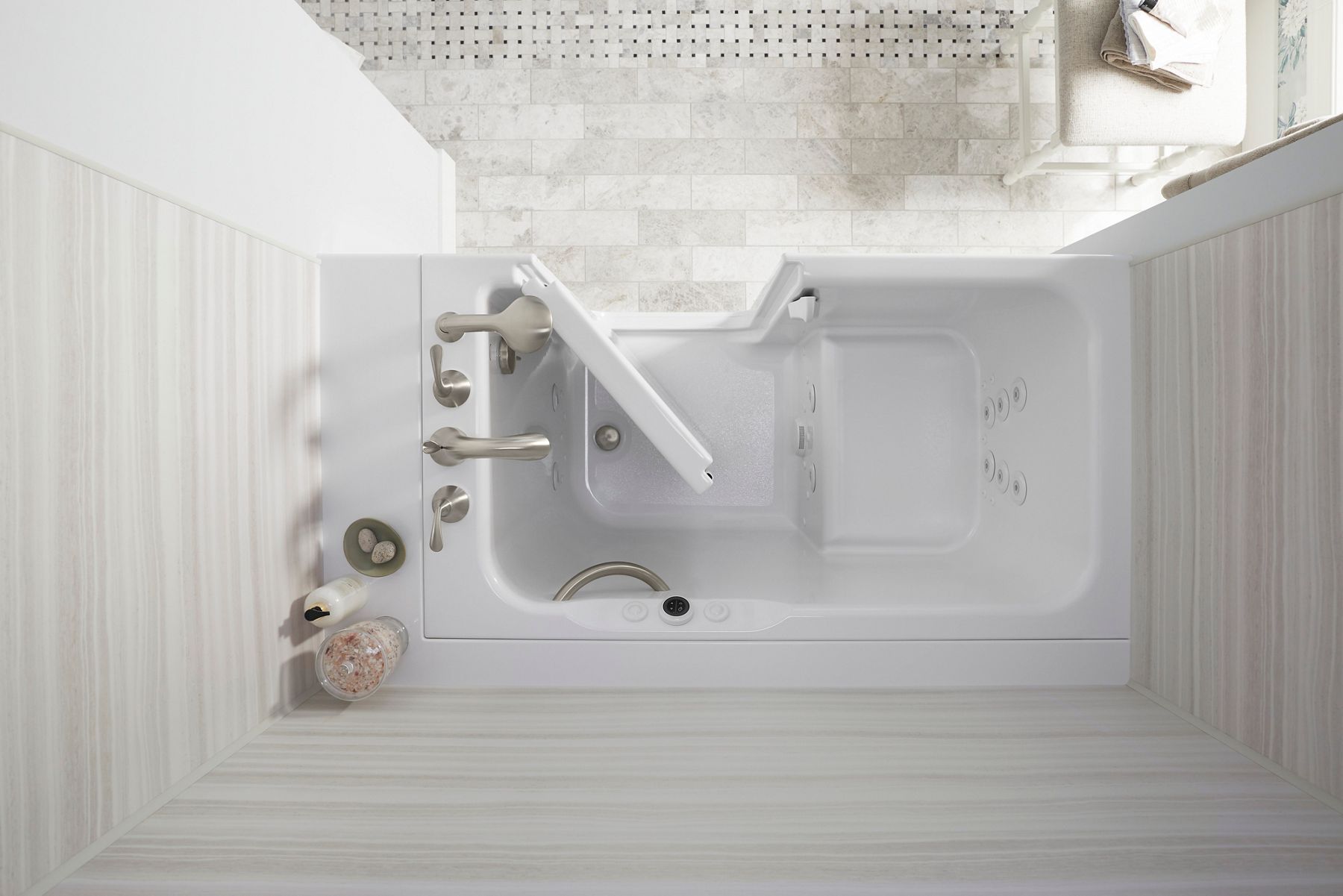 Kohler walk in bath tub with door entry and a grab bar in a bathroom