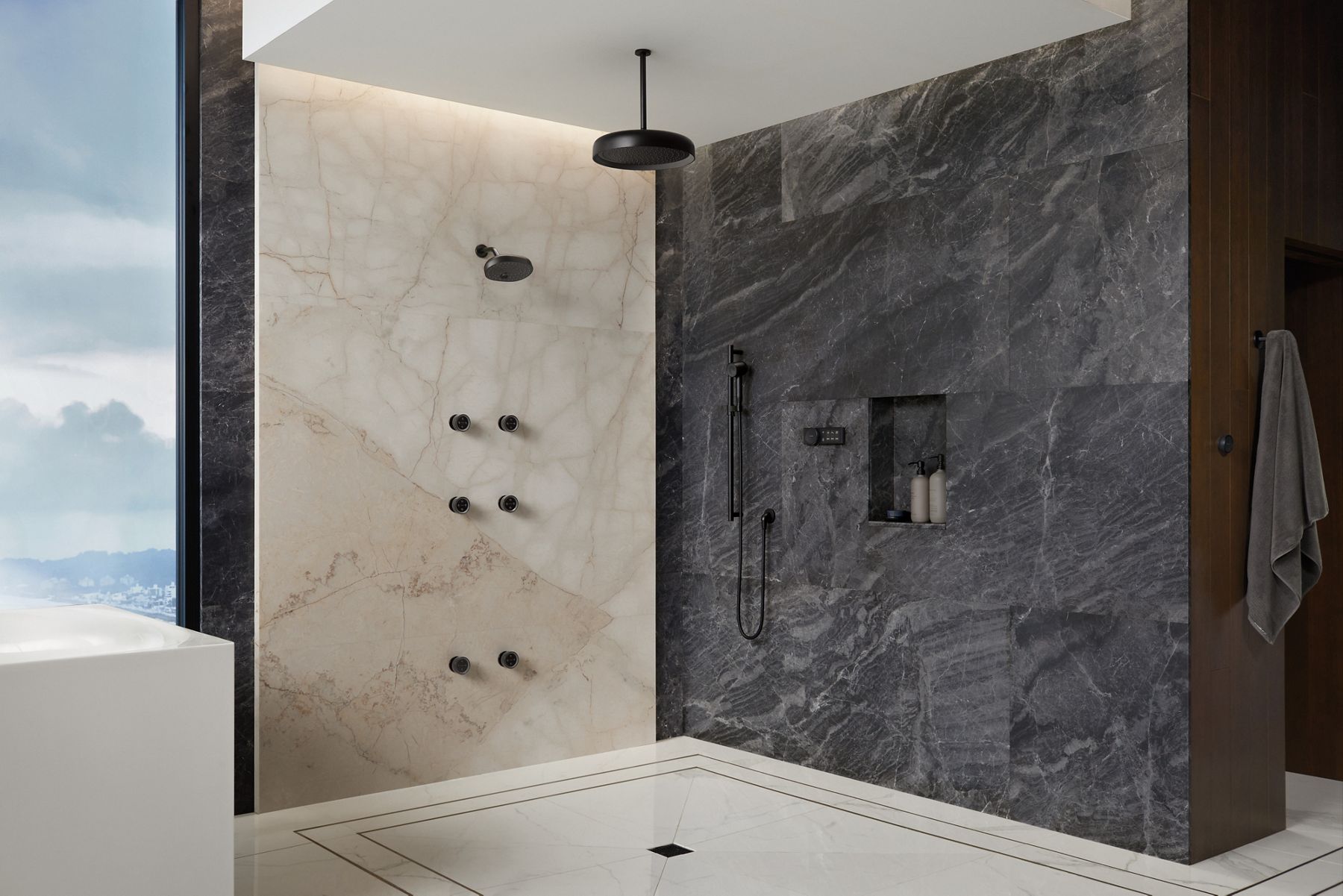 A penthouse bathroom with floor to ceiling windows, large black and white marble shower with KOHLER Statement showerhead, rainshower, and body sprays, Anthem digital shower controls, and aStillness freestanding bath.