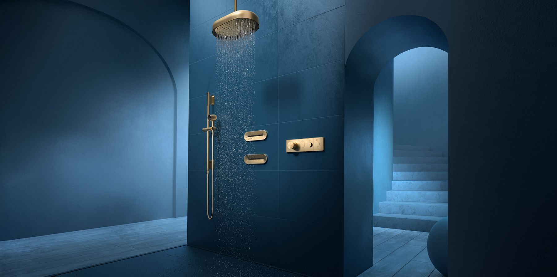 A deep blue shower with arched doorway, oval KOHLER Statement rainhead, two oblong body sprays, handshower, and KOHLER Anthem digital shower controller.