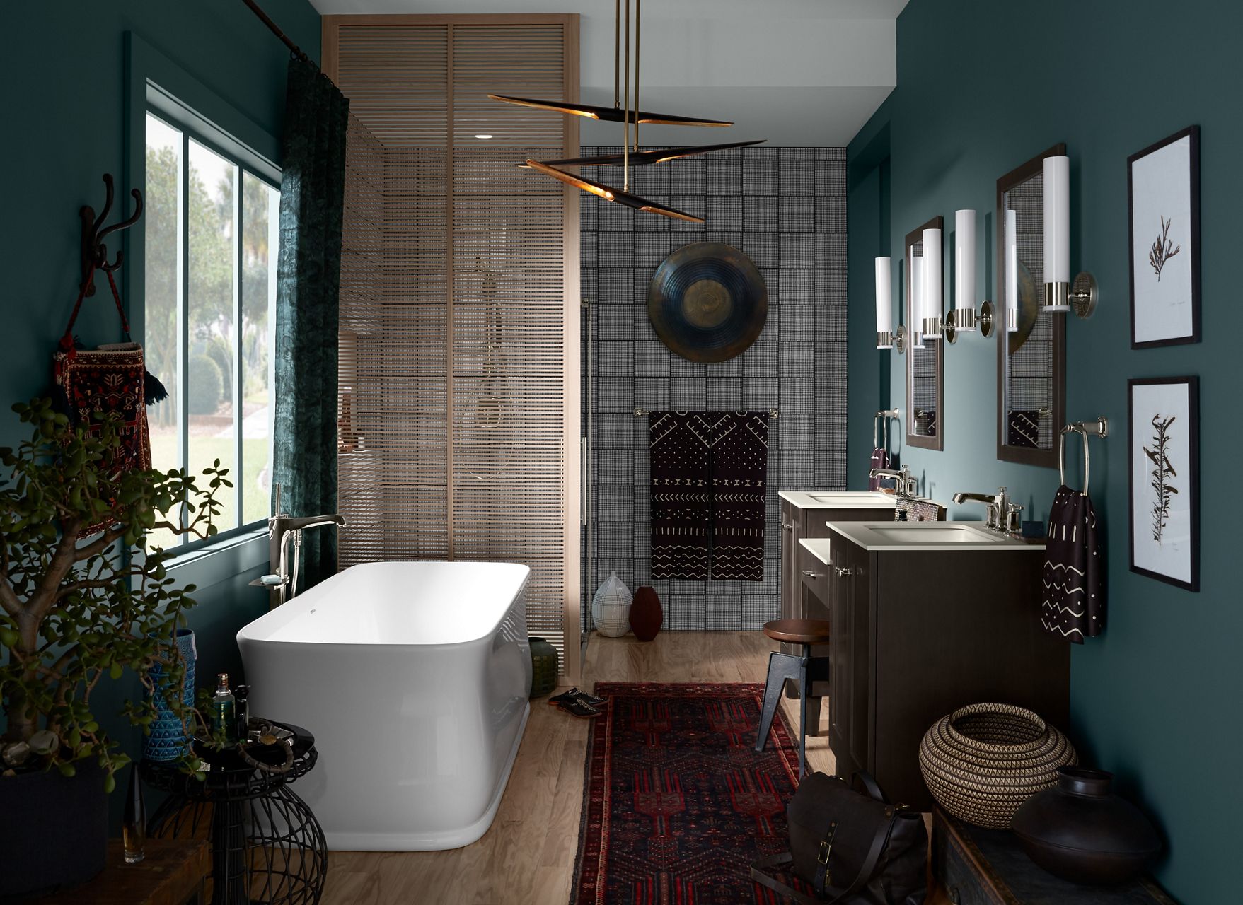 An eclectically styled modern bathroom with greyish-green walls, featuring a textured accent wall, Imperator freestanding bath, and double Poplin vanity in Felt Grey paired with artfully crafted accessories and illuminated chandelier.