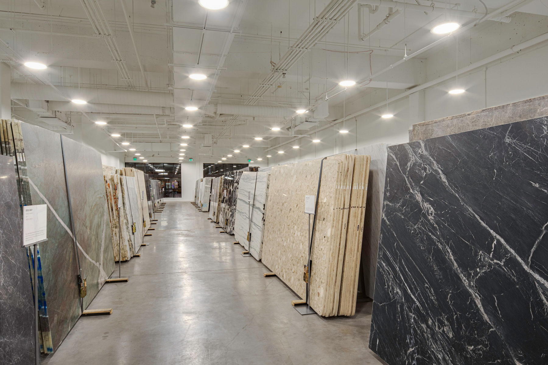 Marble and granite slabs displayed in a modern indoor slab yard for designers and homeowners