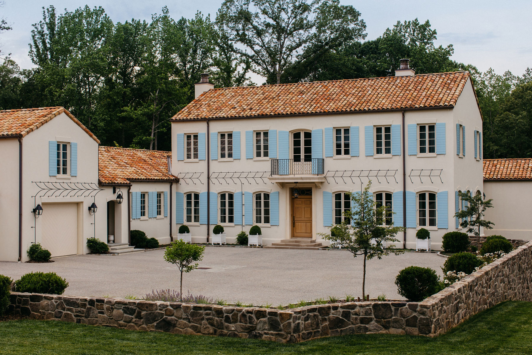 Charming residential design showcasing symmetrical windows, tiled roof, and decorative ironwork for a timeless aesthetic
