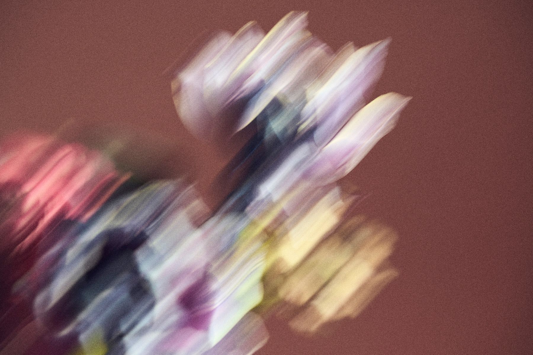 Abstract, motion-blurred composition of glazed ceramic tiles, capturing soft streaks of color and light that evoke artisanal glaze variation