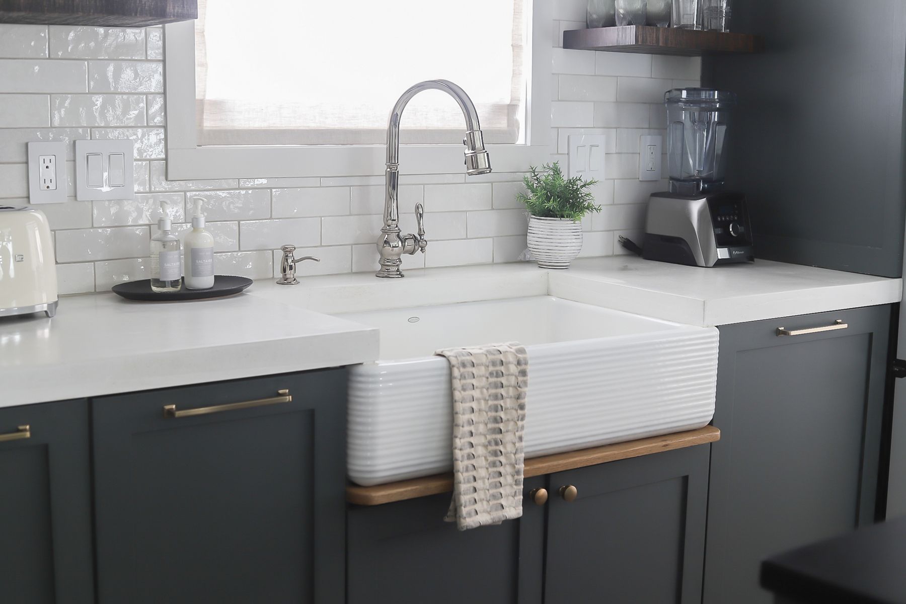 High contrast kitchen with KOHLER apron-front Whitehaven sink with Artifacts kitchen sink faucet
