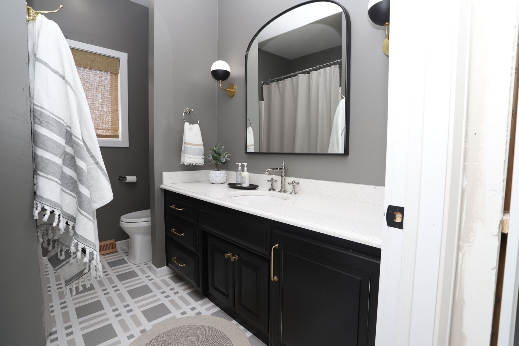 High contrast bathroom with KOHLER sink faucet, vanity, and toilet