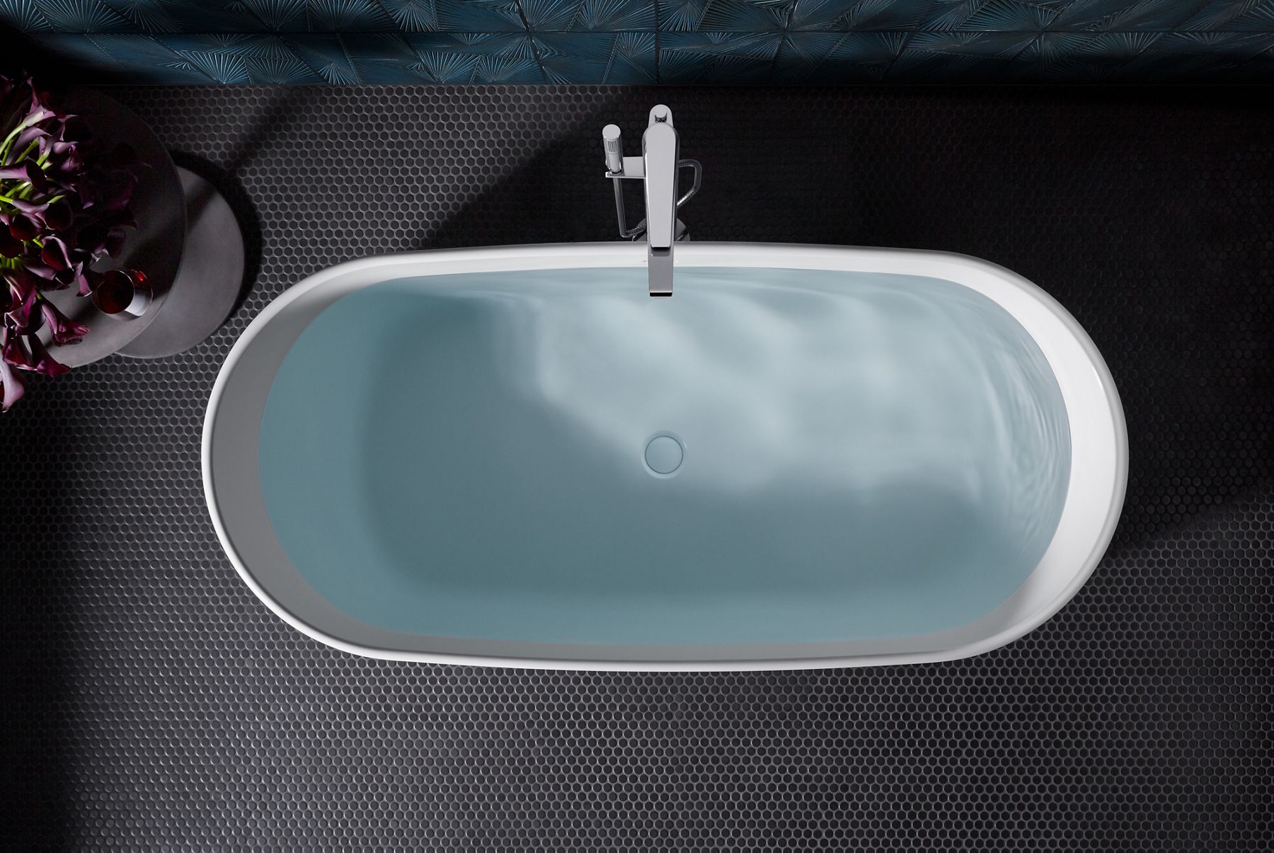A white KOHLER Ceric freestanding bath full of water, as seen from above.