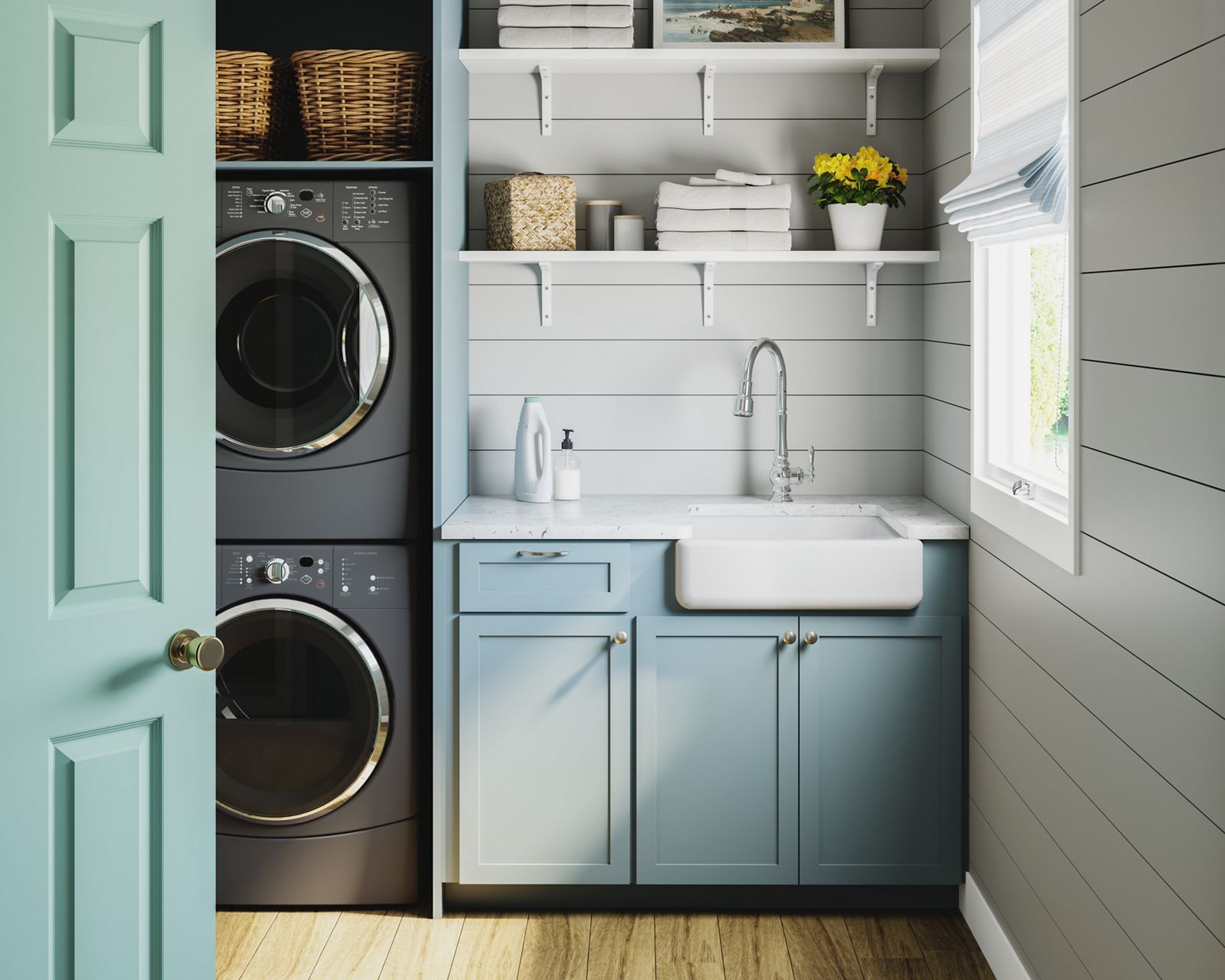A modern farmhouse utility room, with stacked washer dryer, white countertop, white KOHLER farmhouse sink and single-lever faucet, light blue cabinets, and white open shelving with folded towels, flowers, and supplies.