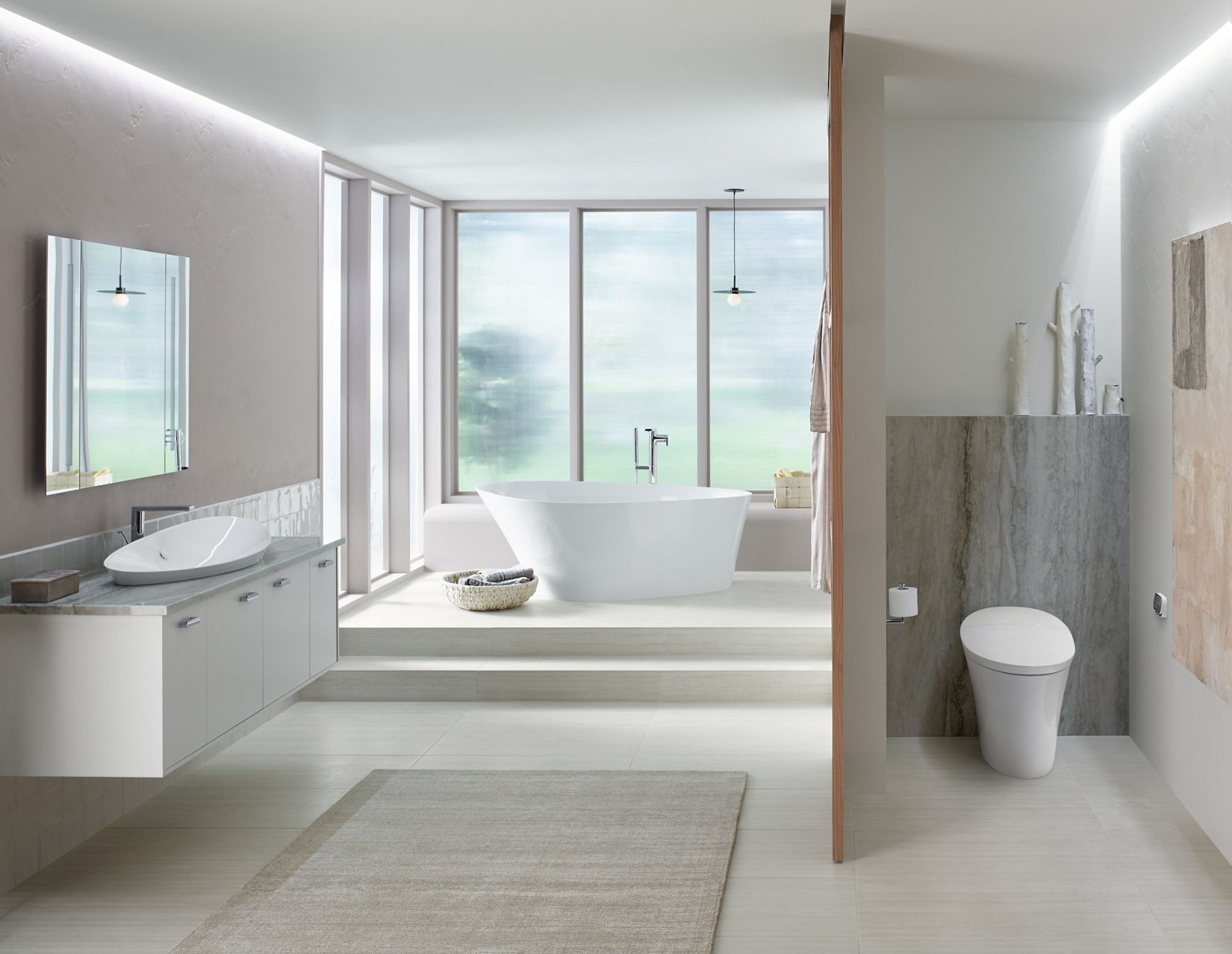 An airy bathroom with large windows, KOHLER Veil freestanding bath, wall mounted vanity with Veil vessel sink, and separate alcove with Veil intelligent toilet.