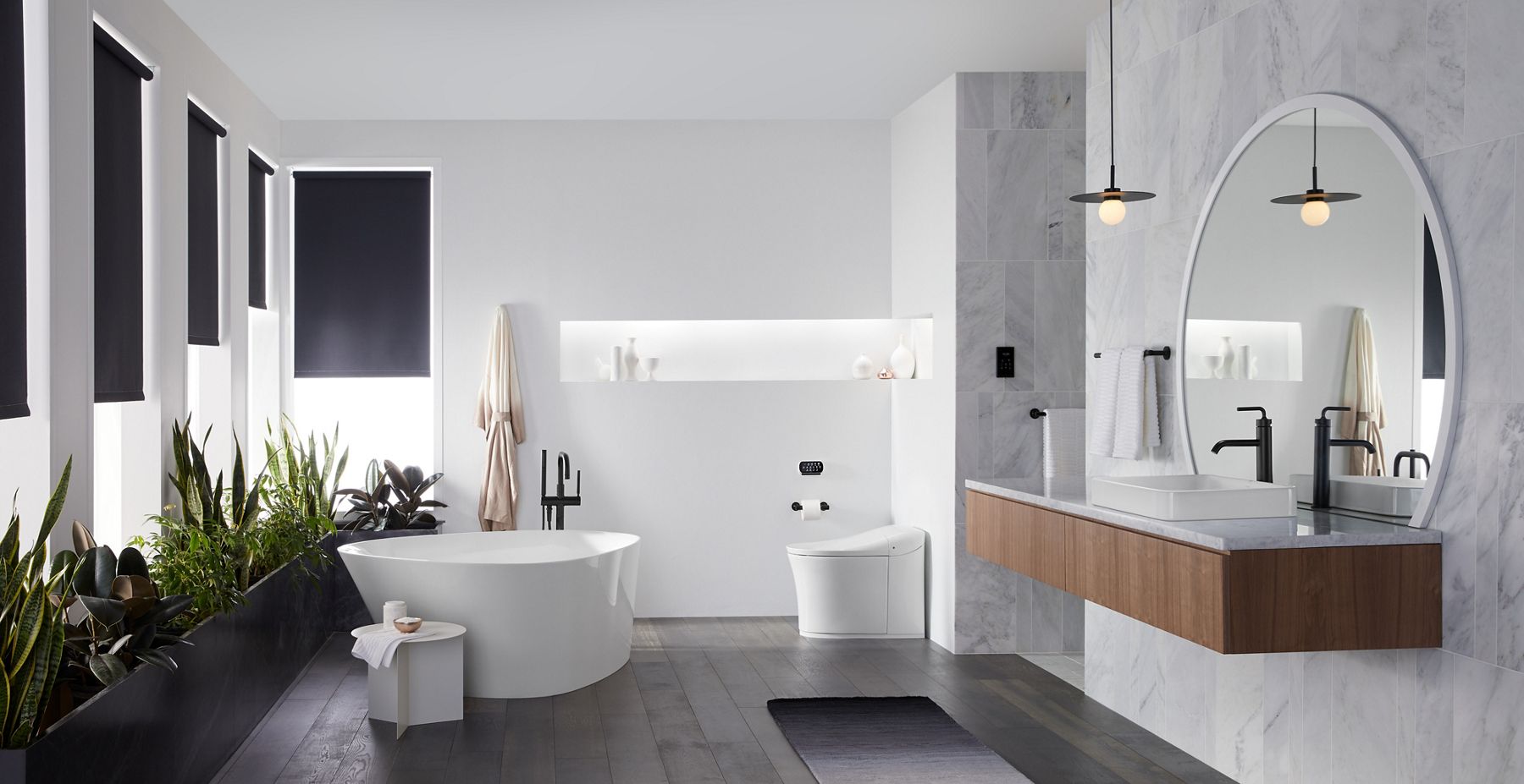Une grande salle de bain monochrome de style Japandi, avec baignoire autoportante blanche KOHLER Veil, remplisseur de baignoire noir mat Purist, toilette intelligente blanche Eir, lavabo en surface blanc et robinet de lavabo de salle de bain noir mat Purist à poignée unique à levier.