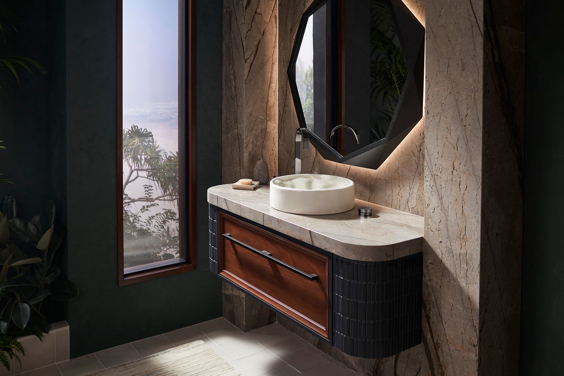 An off-white circular vessel sink on a wall-mount vanity in reddish wood and dark gray.