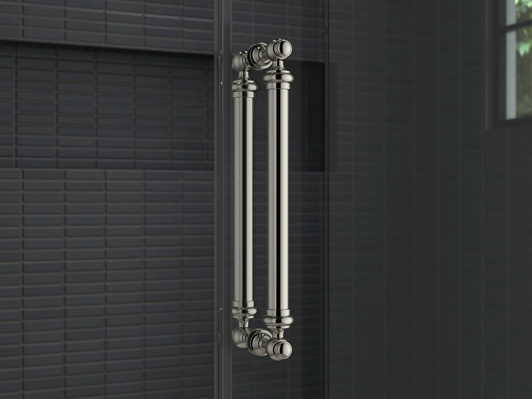 A glass shower door with a traditional style handle in polished chrome.