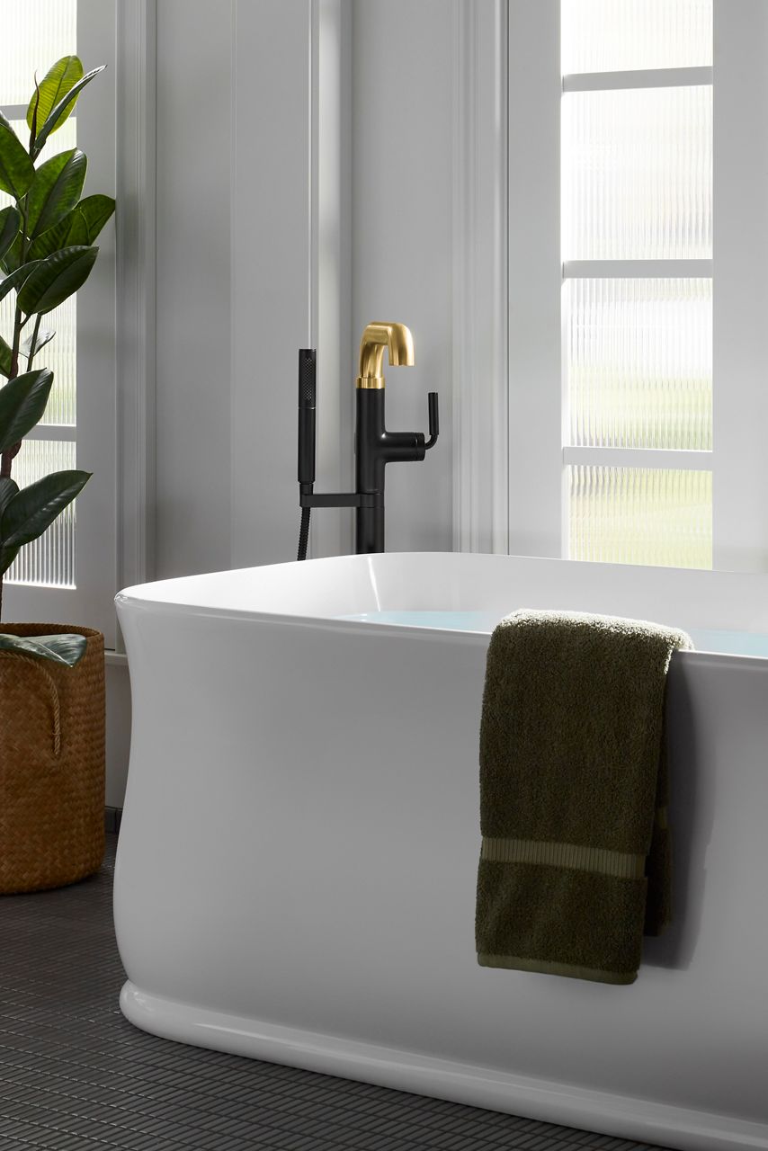 A white freestanding bath with a two-tone bath filler.