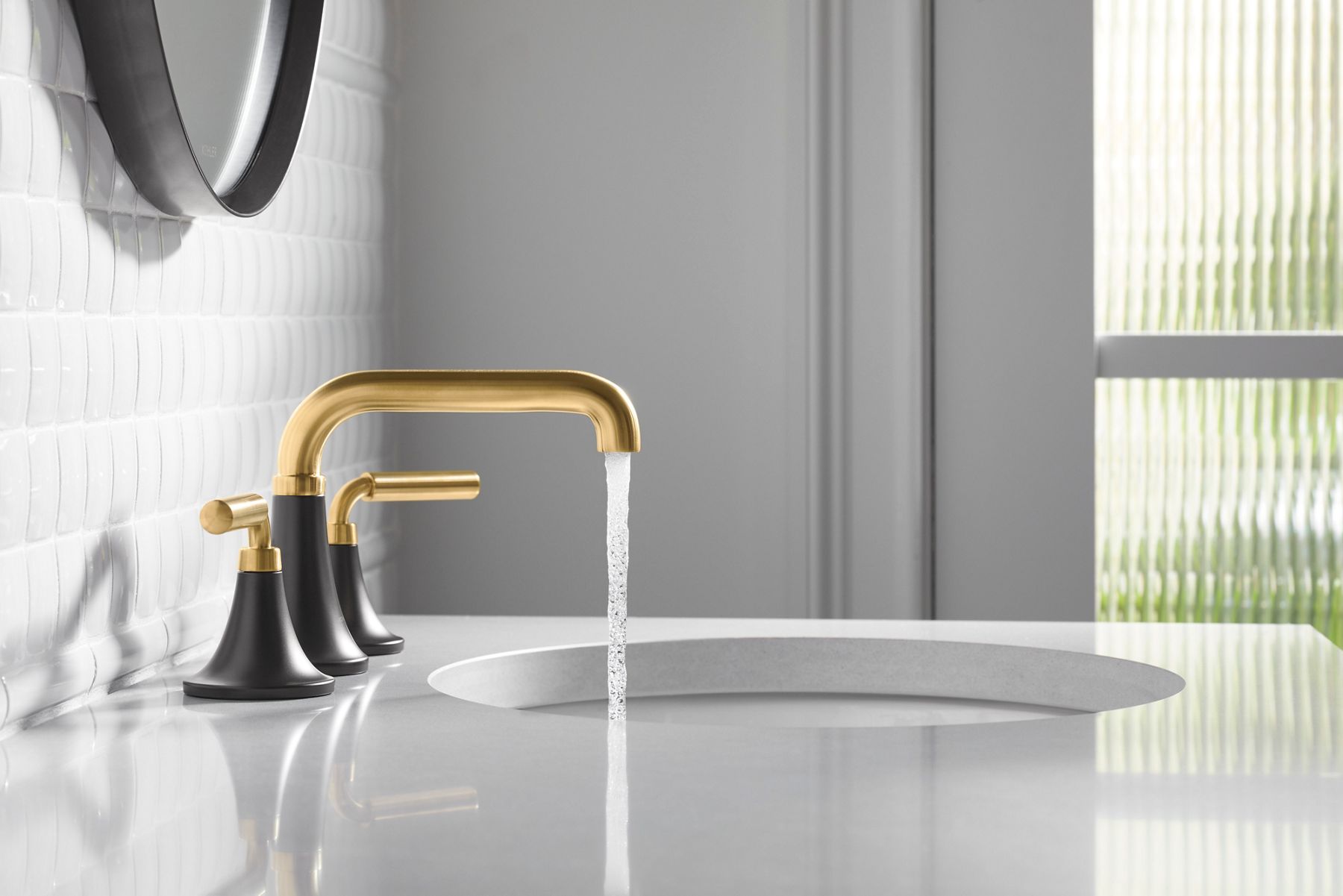  A widespread bathroom faucet pouring water into an undermount sink in a white countertop.