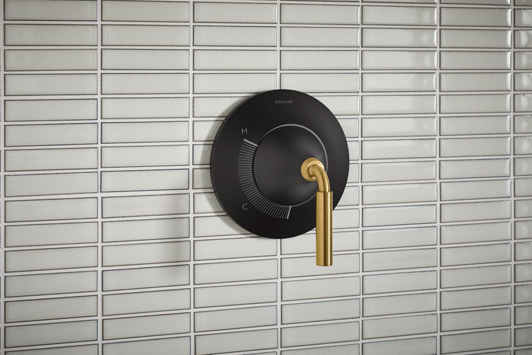  A shower handle in two-tone brushed brass and matte black.