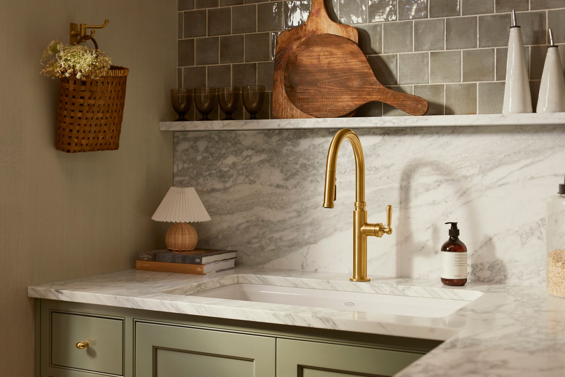 Marbled stone counter tops and back splash with a brushed brass faucet designed by Shea McGee