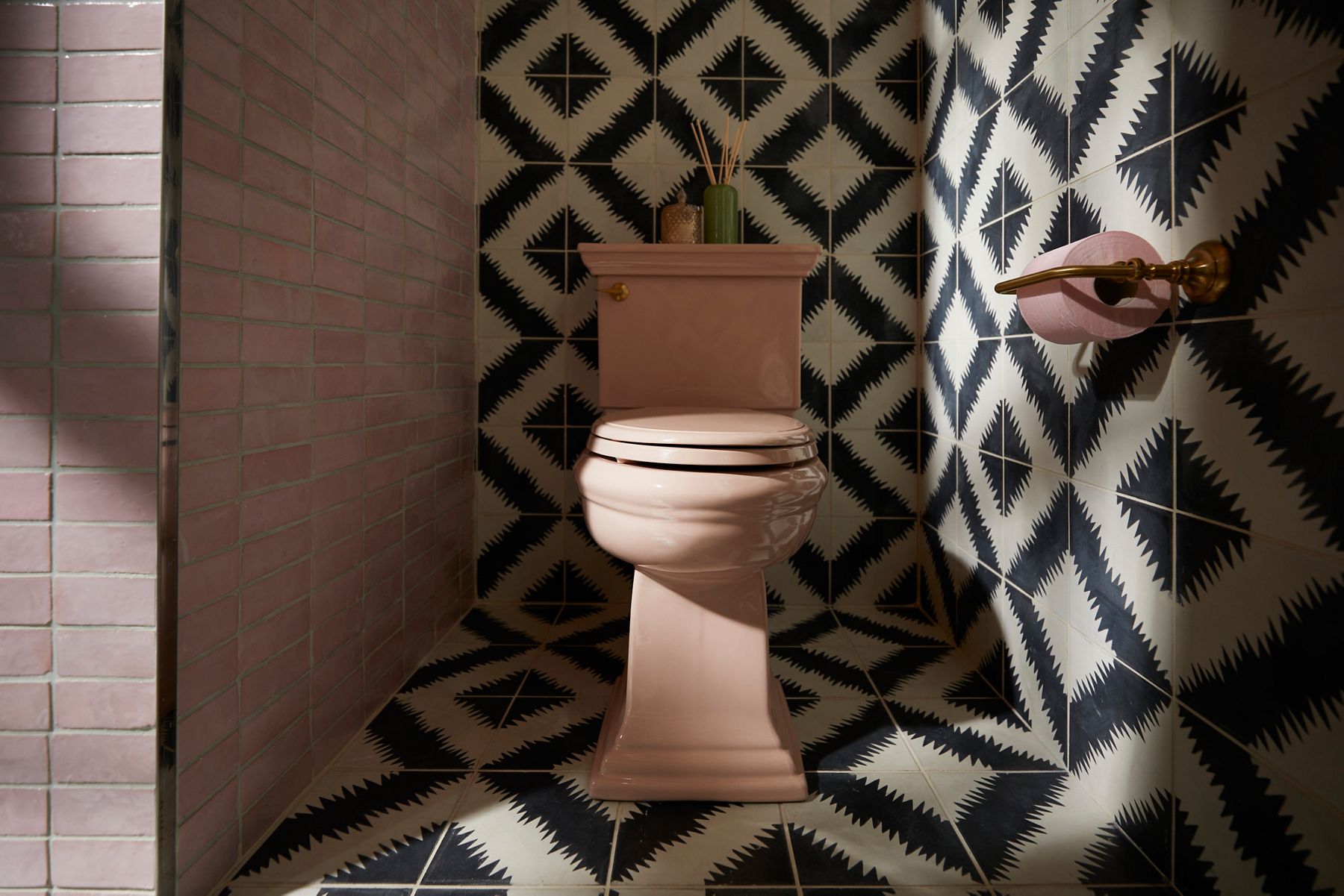 Image of the toileting space in bathroom designed by Justina Blakeney for Kohler's Heritage Color collection. Image focuses on the Peachblow toilet centered in the colorful tile alcove.
