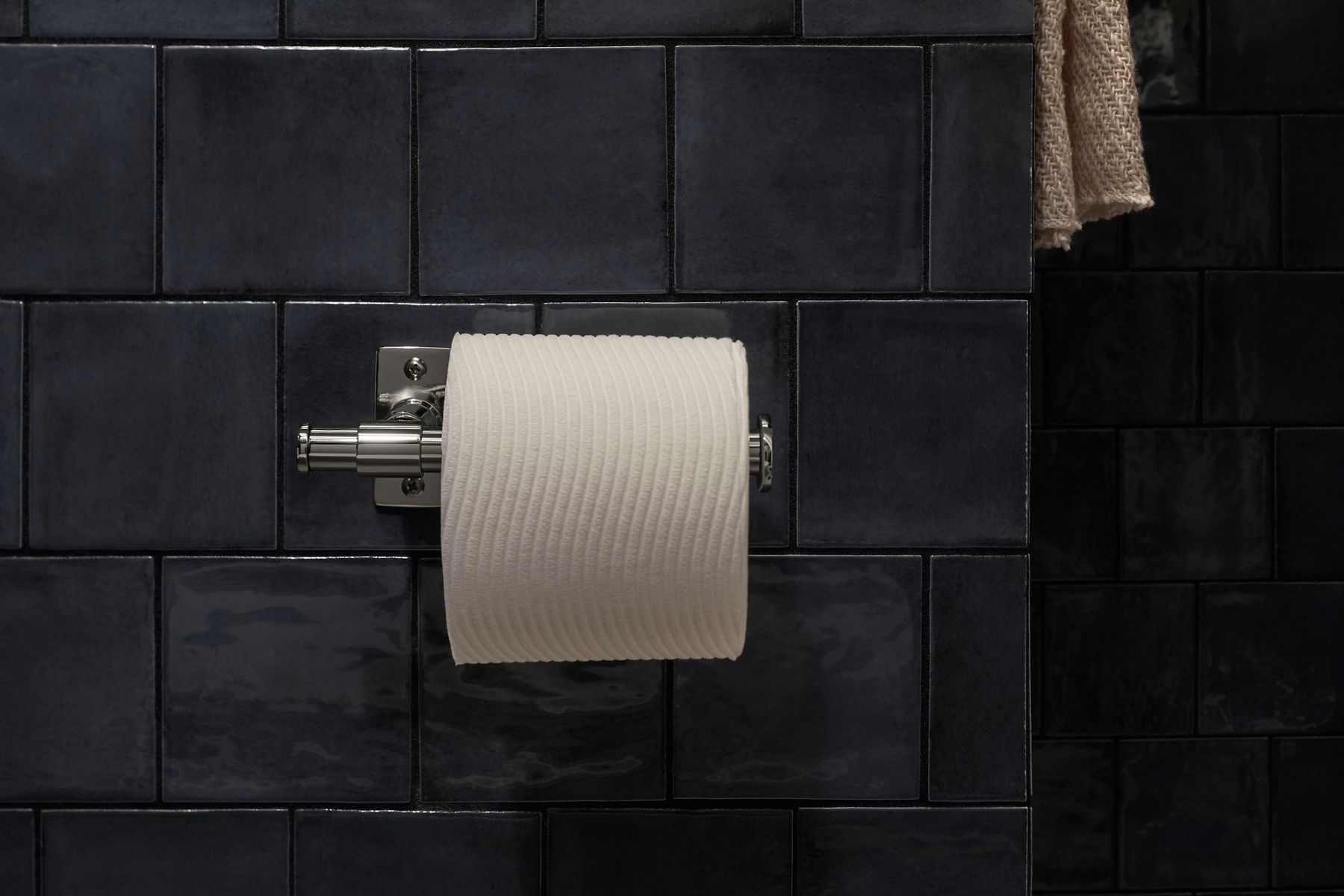 A toilet paper holder designed by Shea McGee with toilet paper on it.