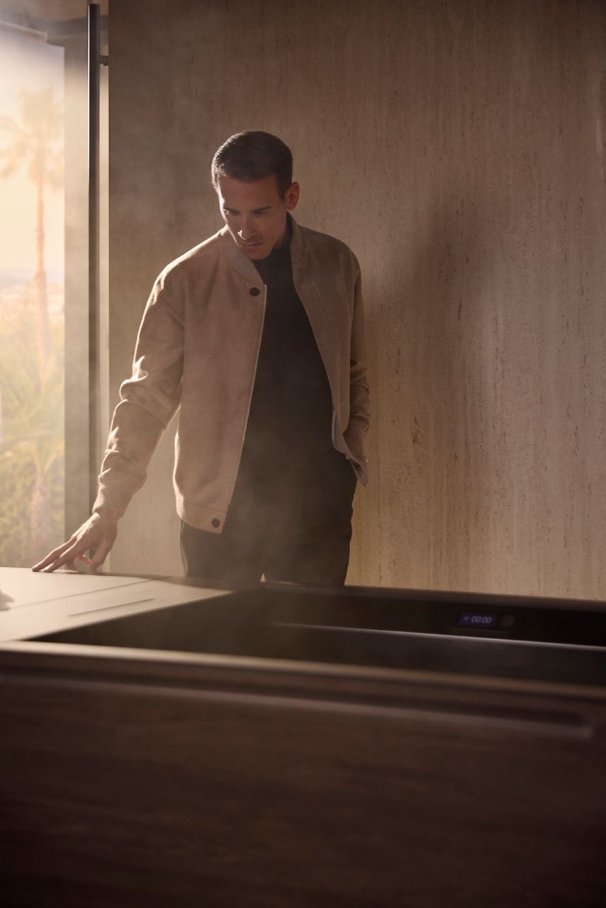 Dr. Jonathon Leary wearing a neutral jacket looking over an ice bath.