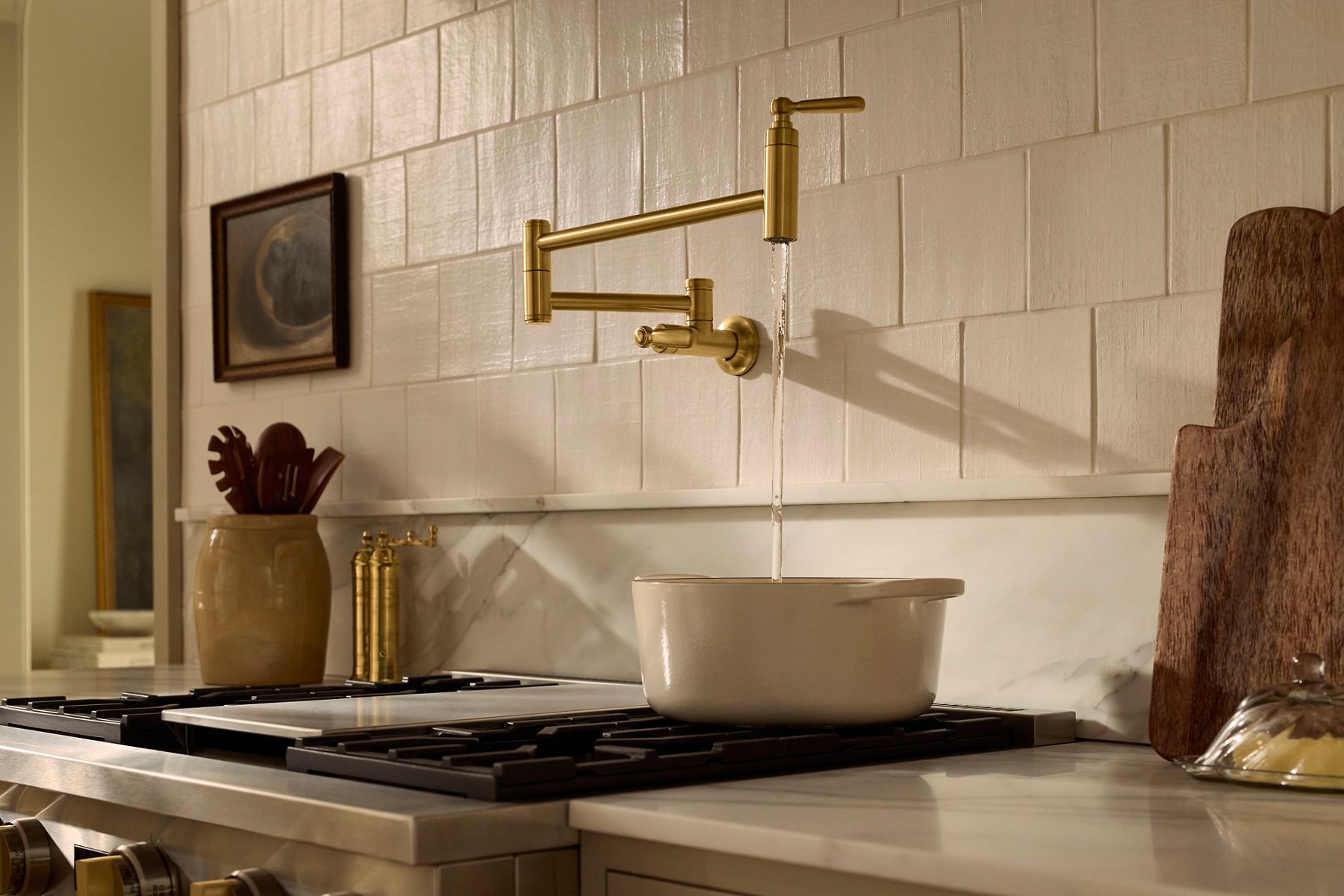 Wall-mounted pot filler faucet installed above a kitchen range and tiled backsplash.