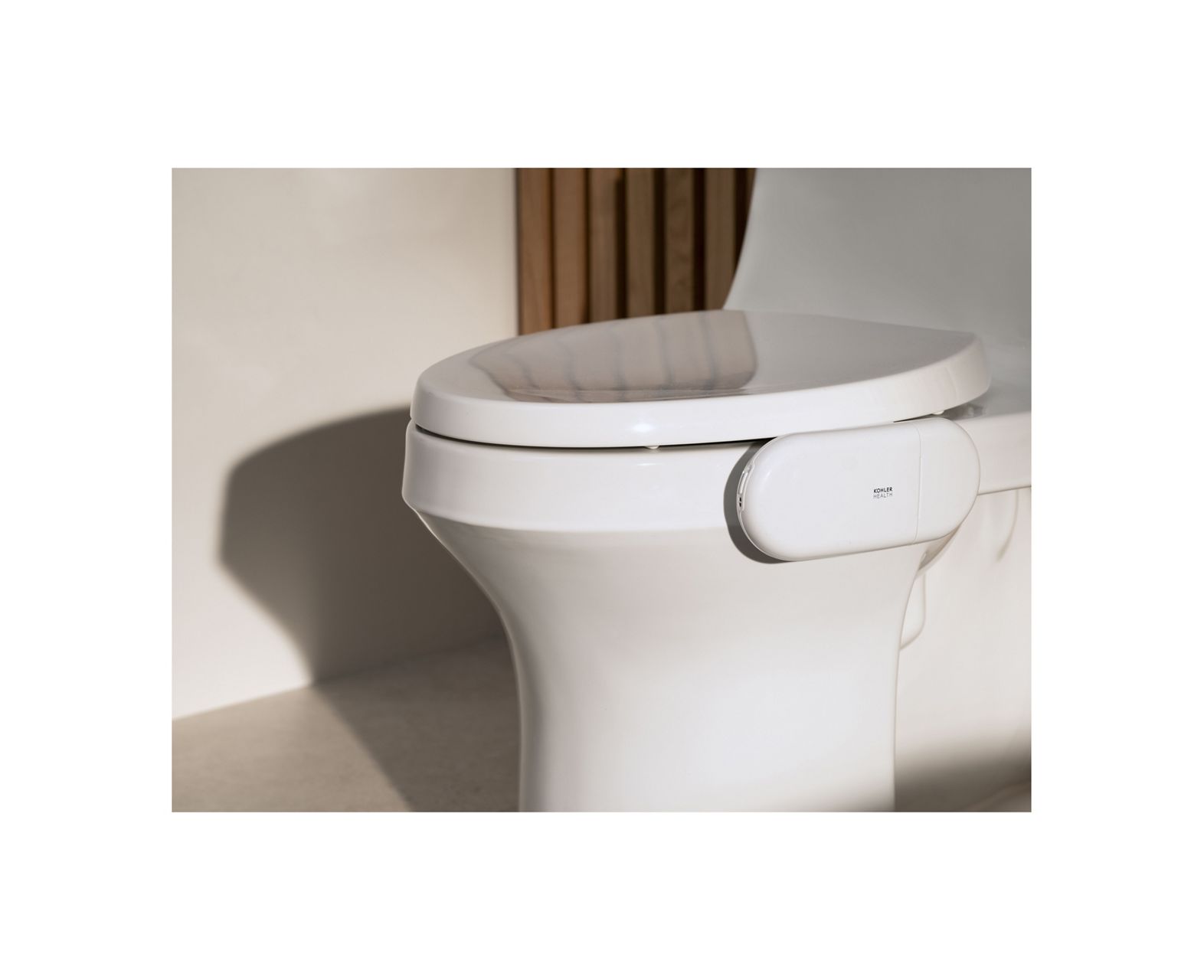Kohler Health device resting on a reflective surface in soft neutral lighting