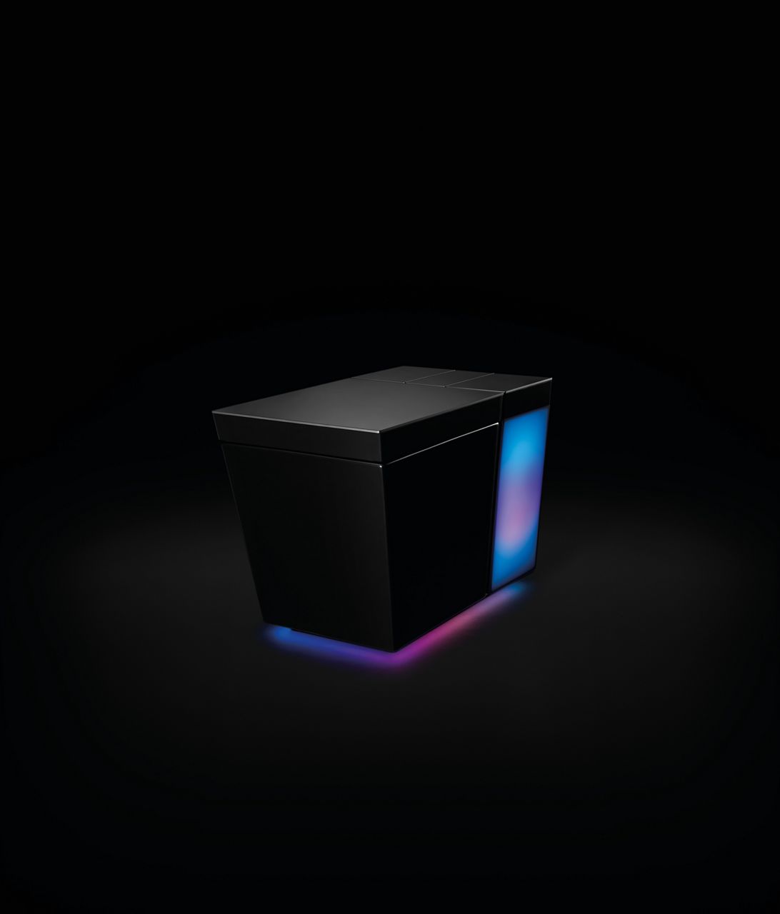 A square black smart toilet with an illuminated back panel in a darkened room.