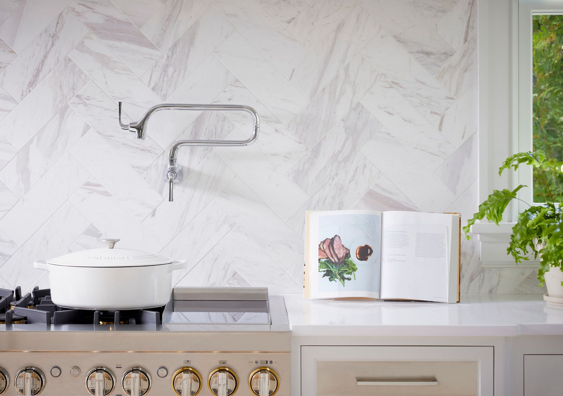 A kitchen stove with a wall mounted pot filler above a pot.