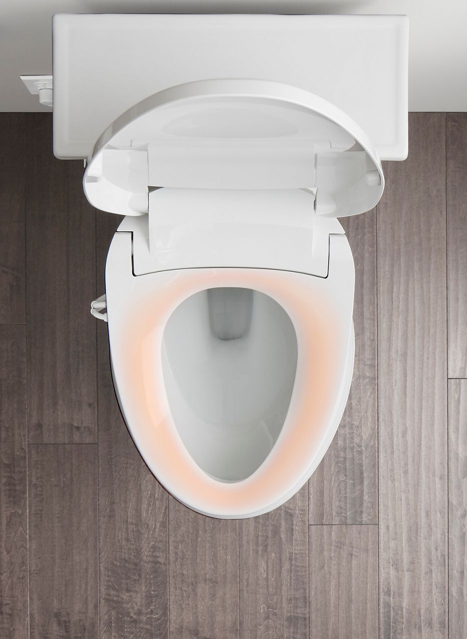 A bidet toilet seat with the seat covered in a pink hue to indicate warmth.