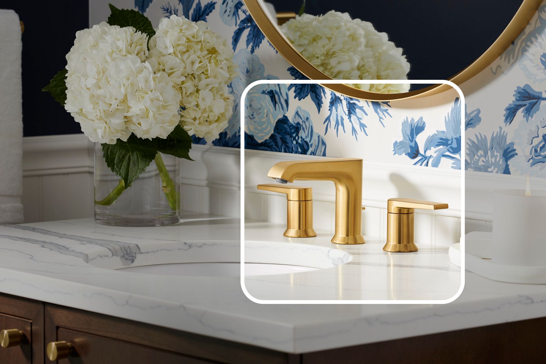 A bathroom vanity with stone countertops and a brushed brass faucet with a lightened graphic square placed over the faucet to give it emphasis