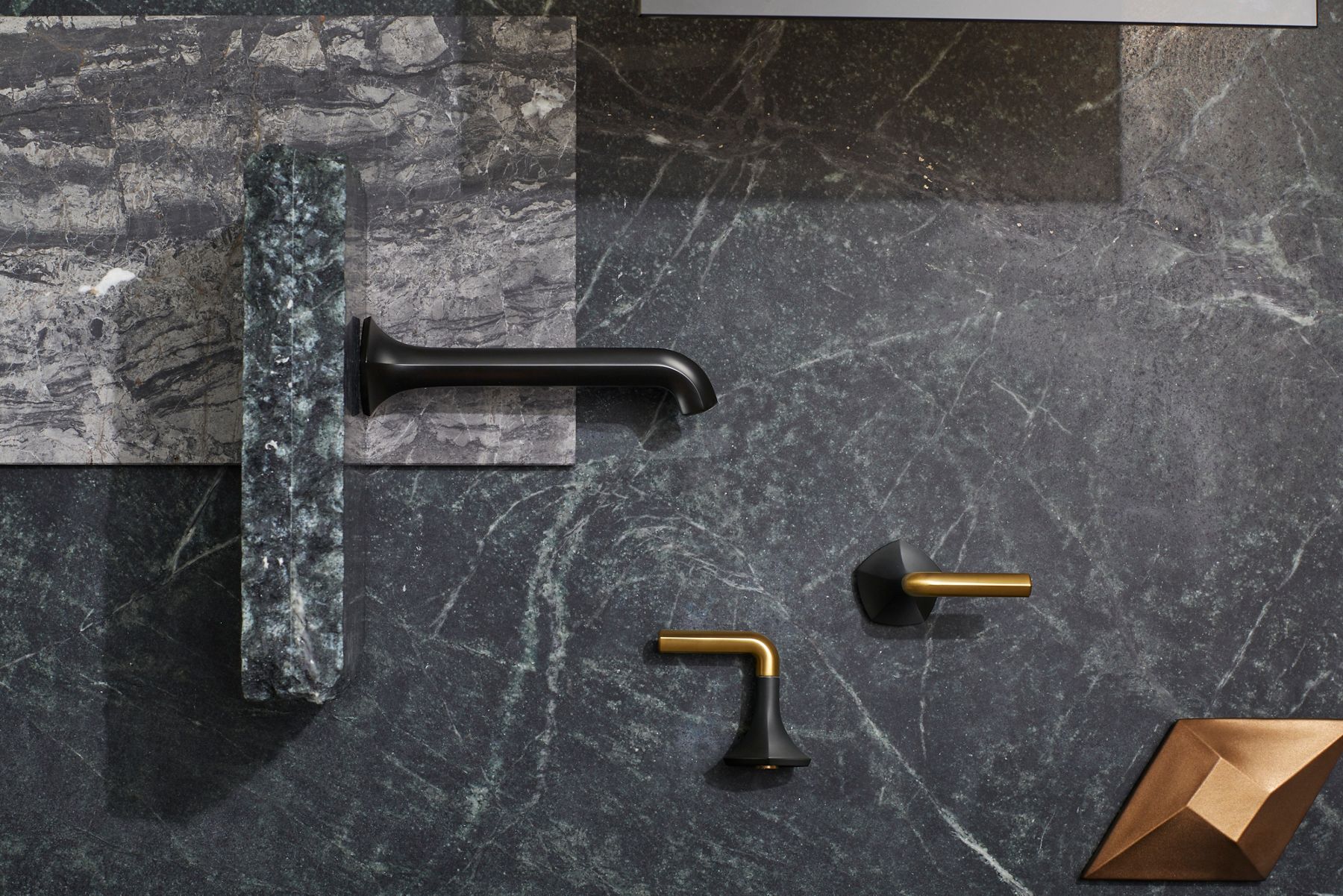 A matte black and gold lever faucet handle. 