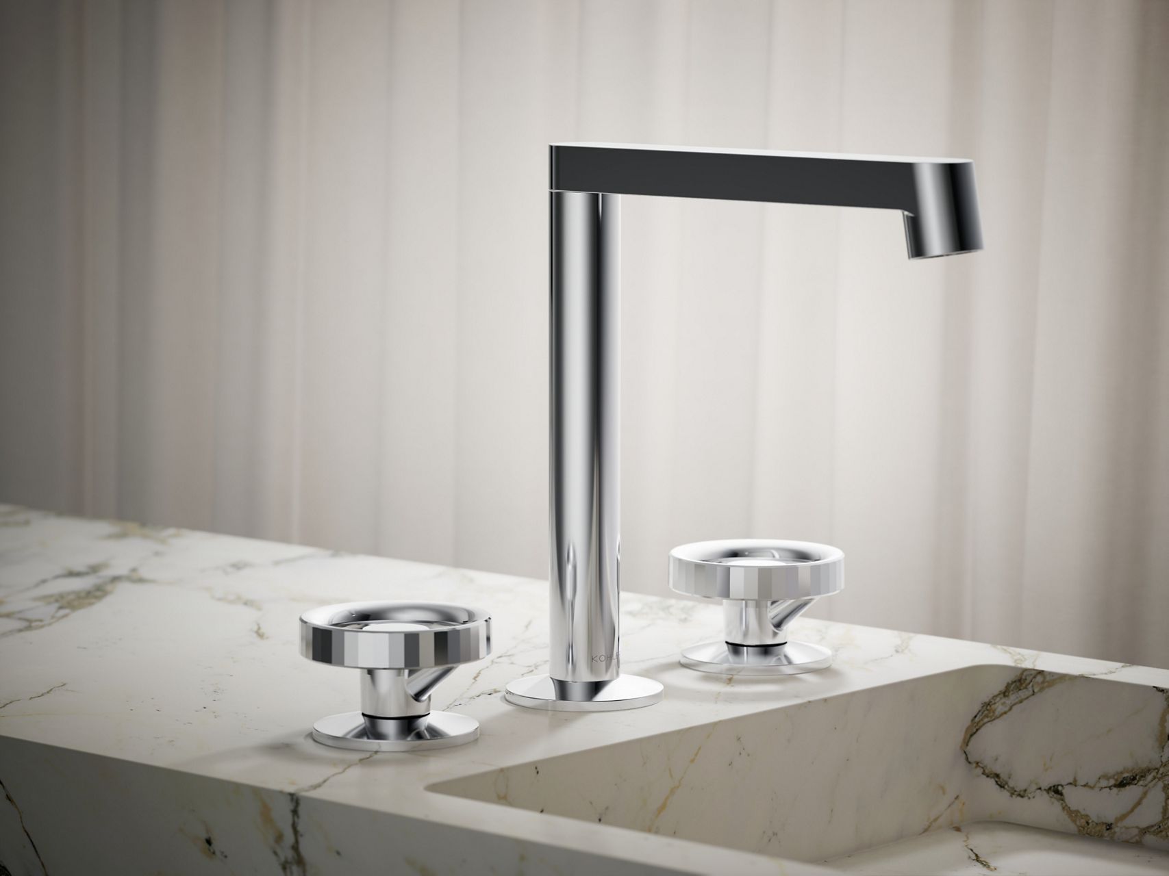 Polished chrome widespread bathroom sink faucet with round handles mounted on a marble countertop.