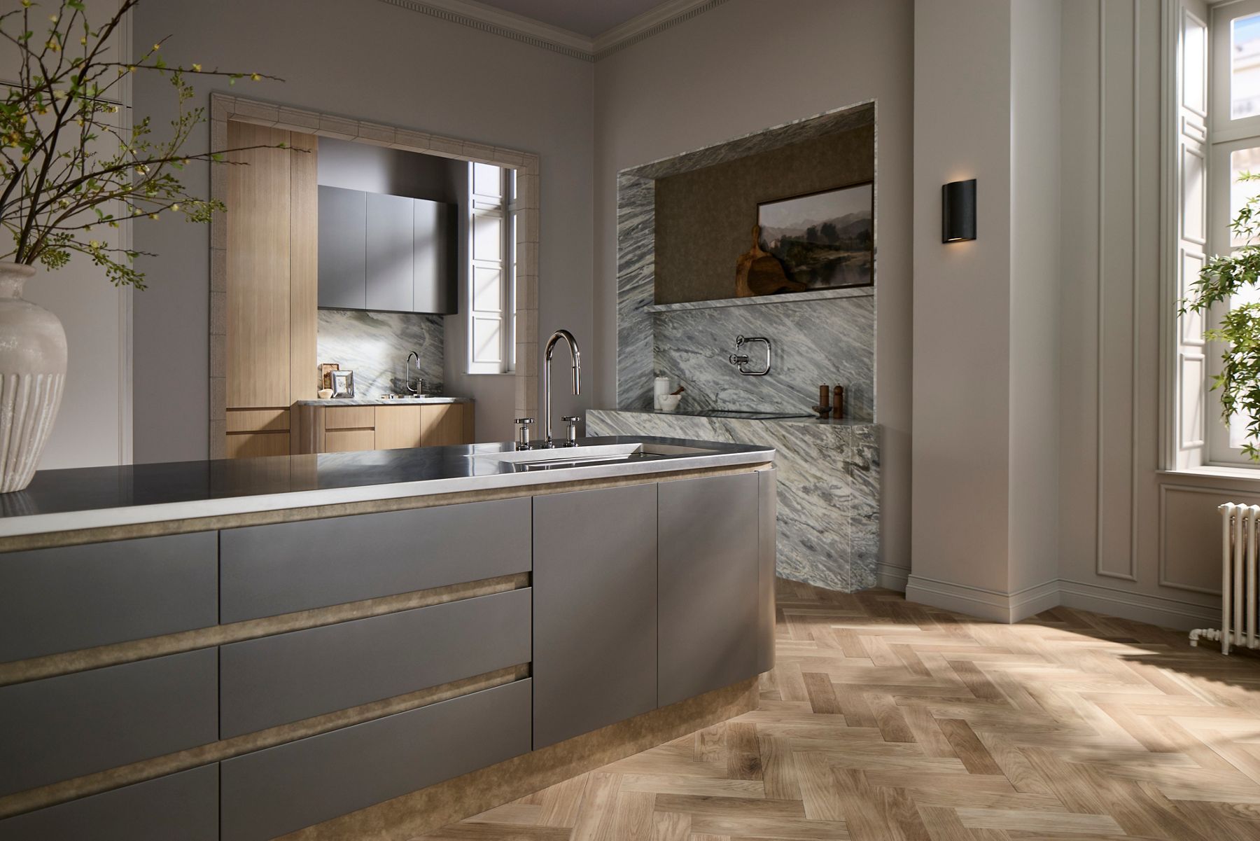 Modern Billet kitchen featuring gray cabinetry, a large island with a polished chrome faucet, marble surfaces, warm wood flooring, and natural light.