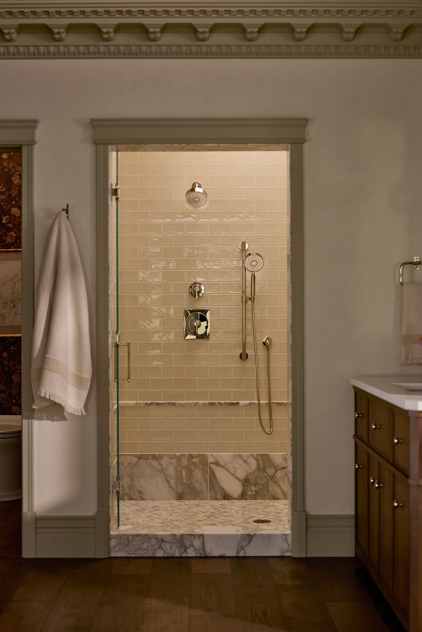 A large walk-in shower featuring the Castia collection shower trim kit in polished chrome.