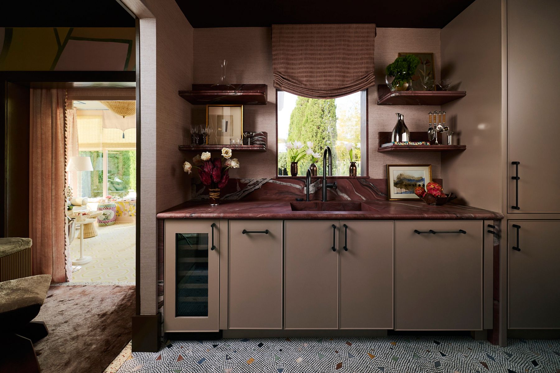 An inviting kitchen space with blush stone counters and matte black faucet and finishes throughout.