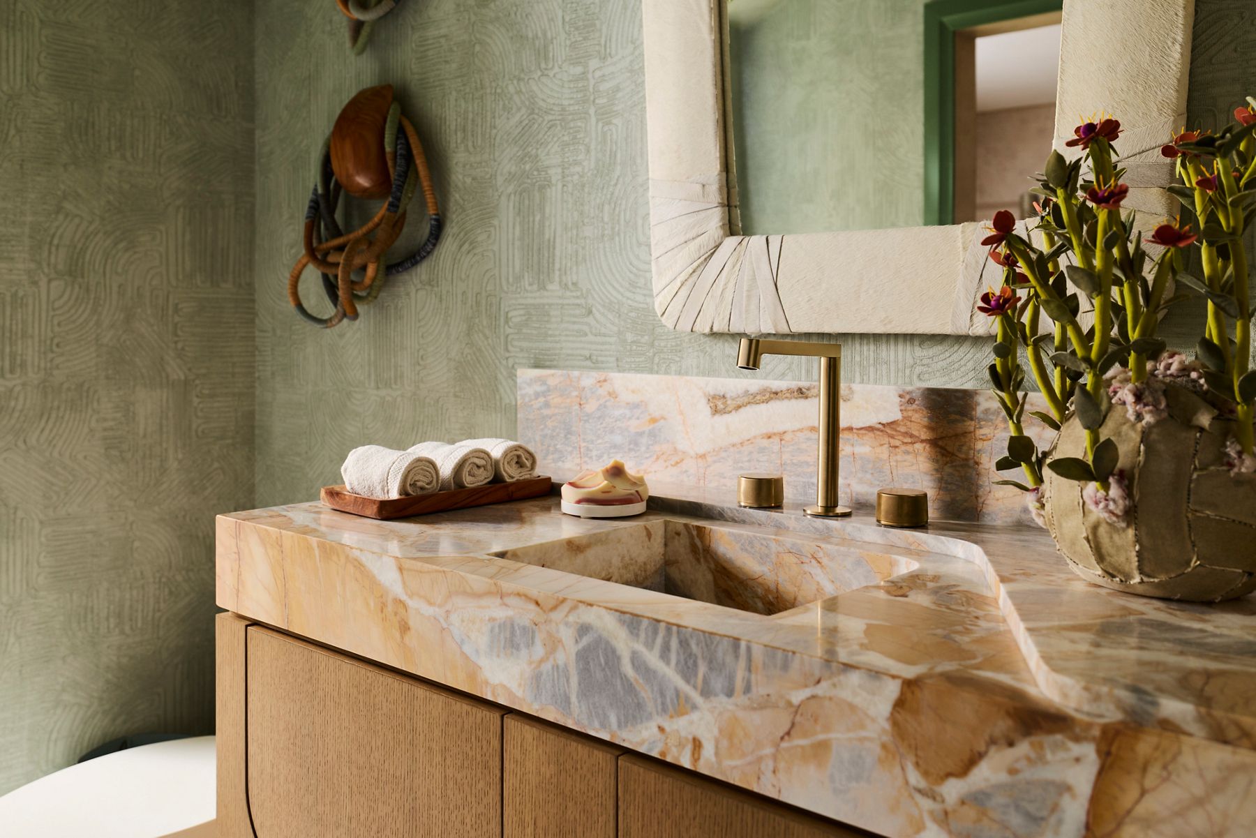 Brushed bronze bathroom faucet set in a carved marble stone sink.