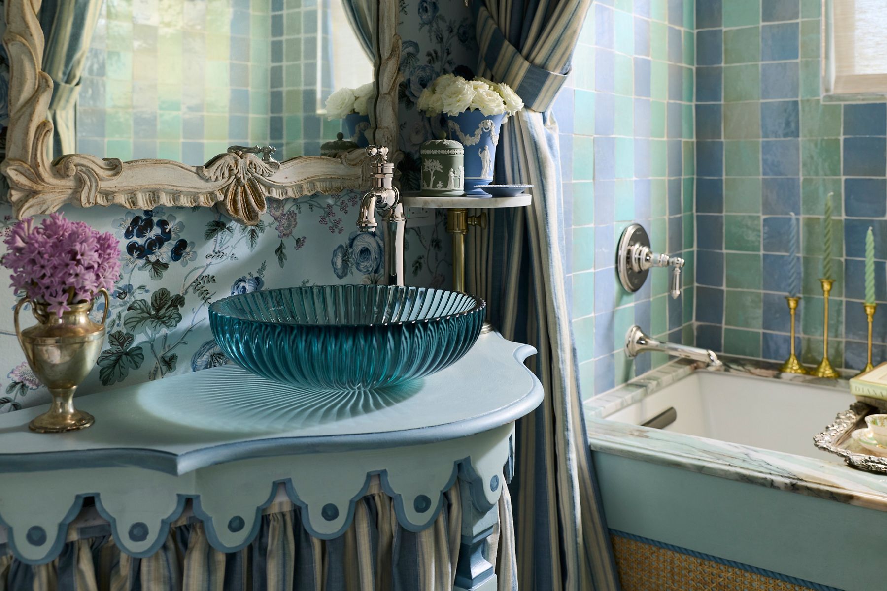 A glamorous blue bathroom featuring a striking vessel sink and polished nickel finishes.
