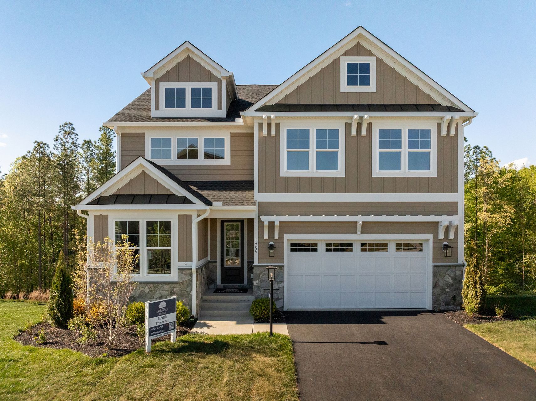 Greenwood Homes model home featuring a two-story exterior with neutral siding, stone accents, and an attached garage.