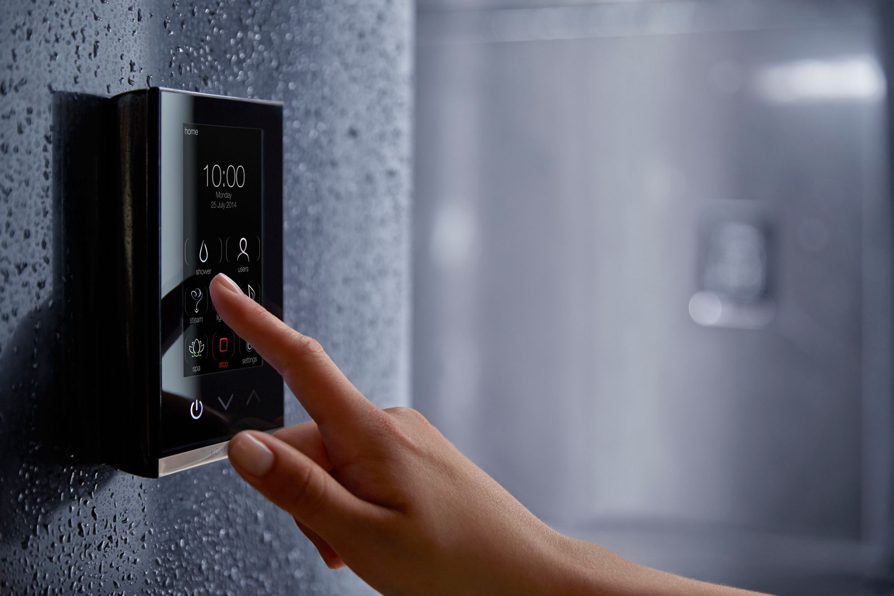 A hand touching a button on a digital shower control