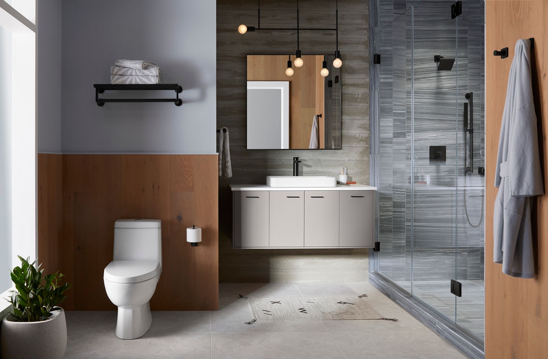 Modern bathroom with a white floating vanity, toilet, glass-enclosed shower, wood accents, and matte black fixtures.
